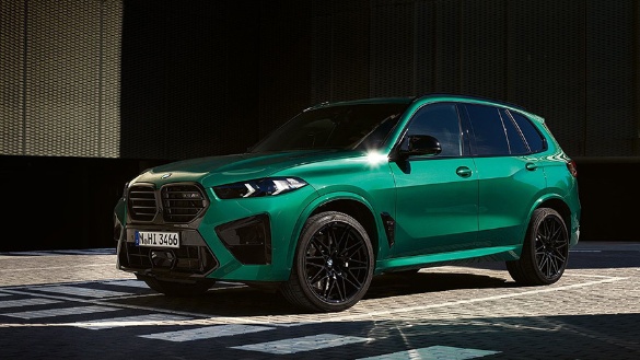 Grüner BMW X5 M auf einem Parkplatz, seitlich von vorne fotografiert.