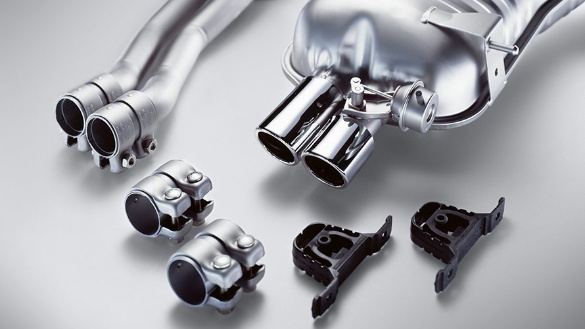 Verschiedene silberne BMW-Autoteile auf grauem Hintergrund.