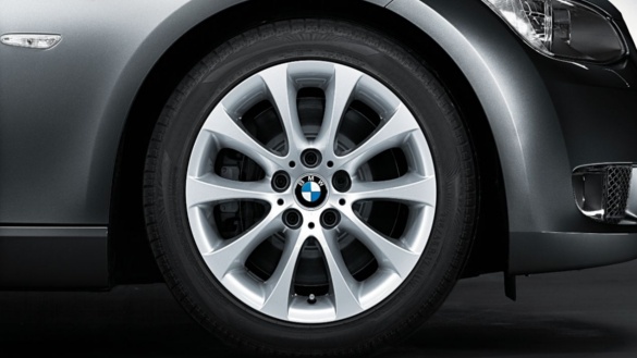 Nahaufnahme eines BMW-Leichtmetallrads an einem silbernen Fahrzeug.