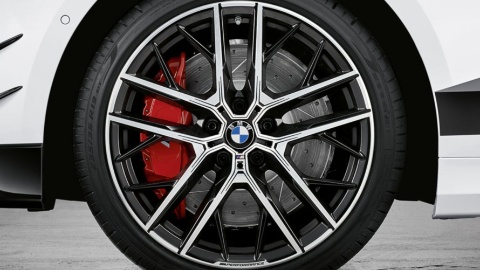 Nahaufnahme eines BMW-Leichtmetallrads mit roten Bremssätteln.