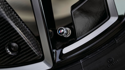 Nahaufnahme einer BMW M Ventilkappe an einem Autoreifen mit schwarzer Felge.