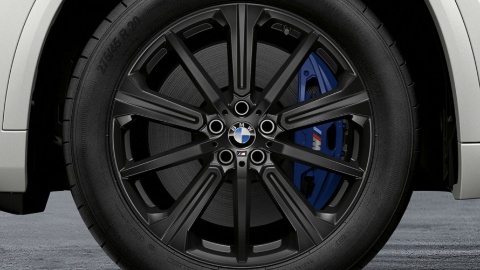 Nahaufnahme eines schwarzen BMW-M-Felgenrades mit blauem Bremssattel.