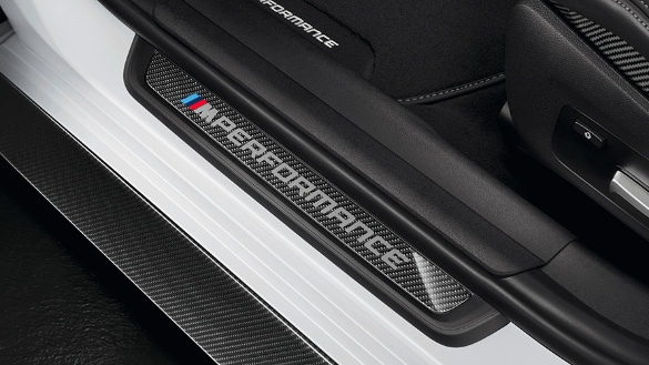 BMW-Einstiegsleiste aus Carbon mit M Performance-Logo in einem Fahrzeug.