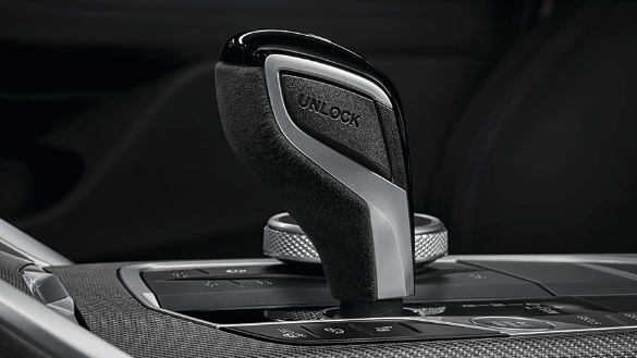 Nahaufnahme eines schwarzen BMW-Autowählhebels mit Alcantara und silbernen Details.