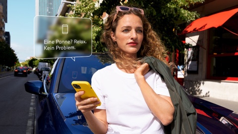 Frau mit gelbem Smartphone vor blauem Auto, Textblase: "Eine Panne? Relax. Kein Problem."