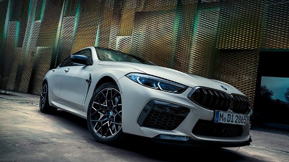 Weißes BMW 8er Coupé in urbaner Kulisse, schräg von vorne fotografiert.