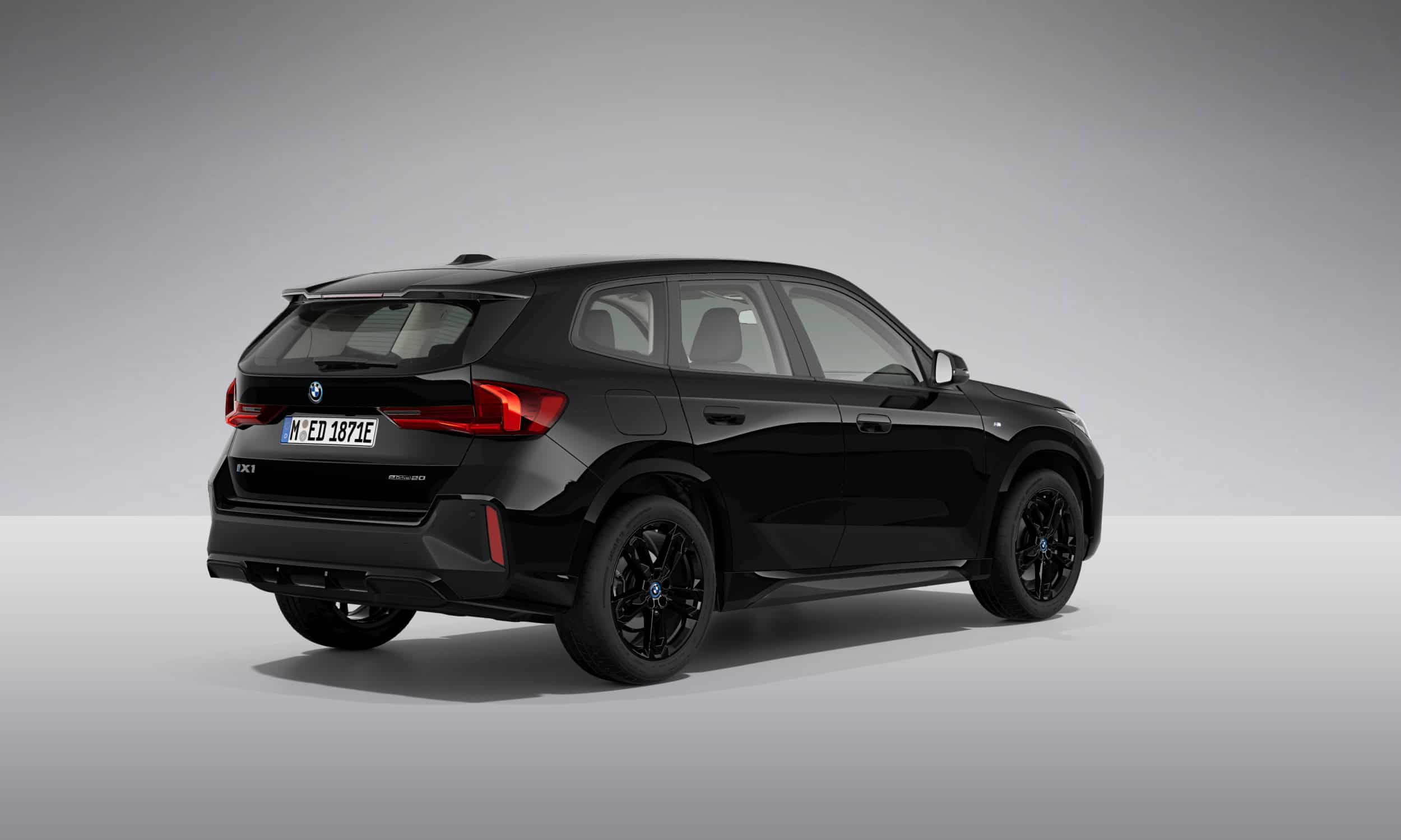 Schwarzer BMW iX1 SUV von hinten, grauer Hintergrund.